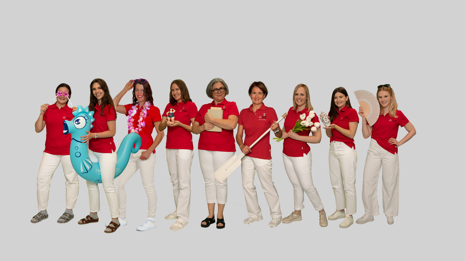 Team der „Apotheke am Mitterweg“ in roten Shirts und weißen Hosen posiert gemeinsam.